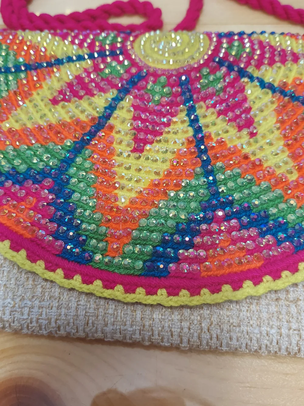Handmade Wayuu-style jute clutch featuring a vibrant, multicolored beaded floral